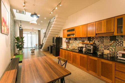 a large kitchen with wooden cabinets and a wooden table at Siro homestay in Danang