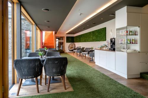 a dining room with chairs and a table with a green rug at Hotel Franks in Oberstdorf