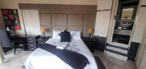 a bedroom with a large white bed with black pillows at Bon A Vie Self-catering and b&b Gonubie Full Solar Power, no load shedding! in Gonubie