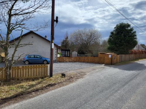 a car parked in a driveway next to a fence at Tanleys - Skye Pod in Grantown on Spey
