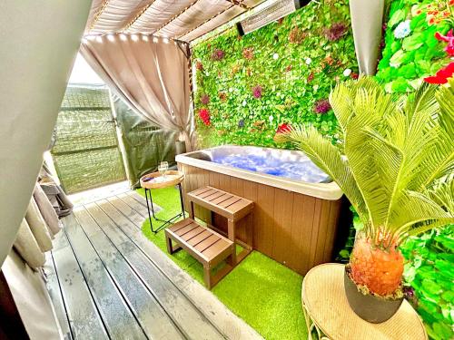 bañera en una terraza con plantas en La lover’s jungle, en Pont-sur-Yonne