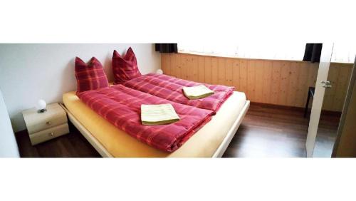 a bedroom with a large bed with red sheets at Wohnung Mit 2 Schlafzimmern Ürbach in Innertkirchen
