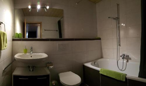 a bathroom with a sink and a toilet and a tub at Wohnung Mit 2 Schlafzimmern Ürbach in Innertkirchen
