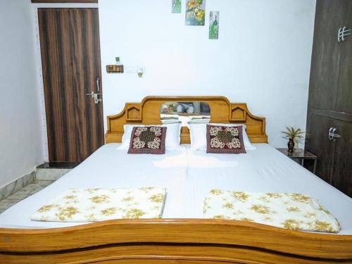 a bedroom with a large bed with white sheets and pillows at Kridha holidays homestay with kitchen in Vrindāvan