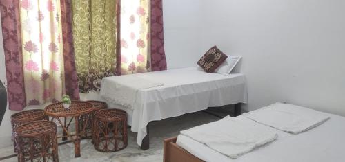 a room with a table and some chairs and curtains at Kridha holidays homestay with kitchen in Vrindāvan