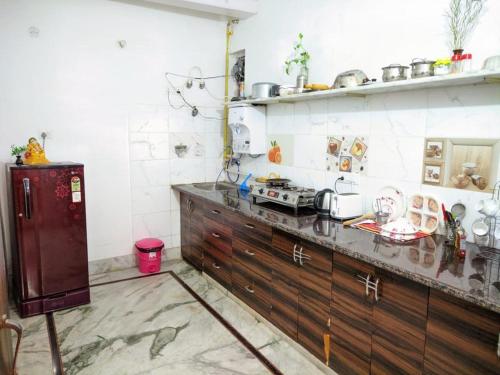 a kitchen with wooden cabinets and a counter top at Kridha holidays homestay with kitchen in Vrindāvan
