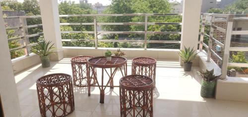 a balcony with four chairs and a table on a building at Kridha holidays homestay with kitchen in Vrindāvan
