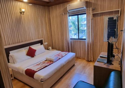 um quarto com uma cama grande e uma janela em Hotel The Mountain View em Rishikesh
