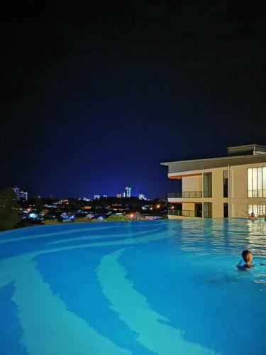 a person swimming in a swimming pool at night at Stylish Micasa 4 Home 3BR+FREE PARKING -Hann's Residence in Sibu