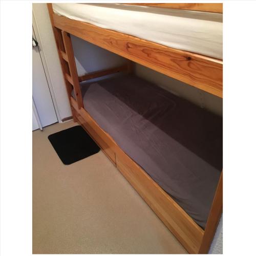 een houten bedframe met een stapelbed eronder bij Bel appartement en résidence in Les Contamines-Montjoie