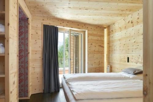 A bed or beds in a room at Alpine Lodge 2-Bett-Wohnung Chesa a la Punt "Bergbahnen All inklusive" im Sommer