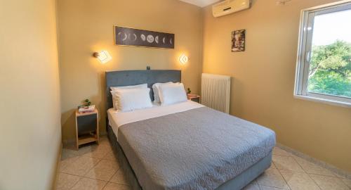 a bedroom with a bed and a window at La Nostra Casa Apartments in Psarou