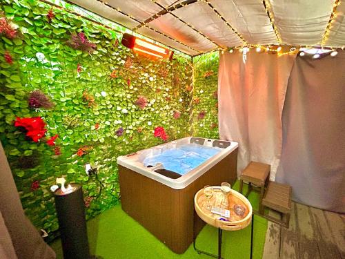 y baño con pared verde y bañera. en La lover’s jungle, en Pont-sur-Yonne