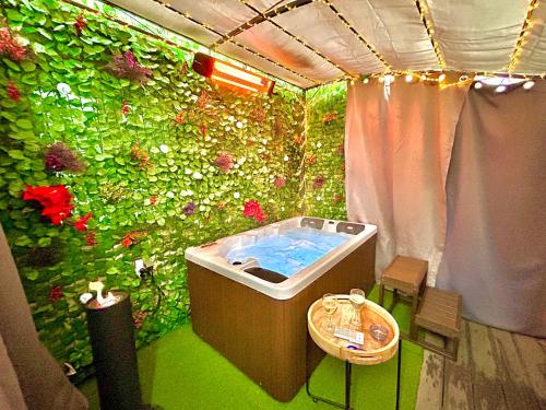 a bathroom with a green wall with a bath tub at La lover’s jungle in Pont-sur-Yonne
