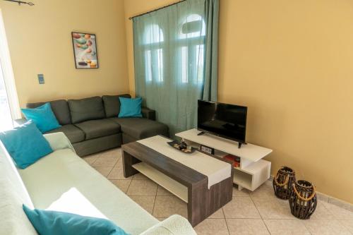 a living room with a couch and a tv at La Nostra Casa Apartments in Psarou