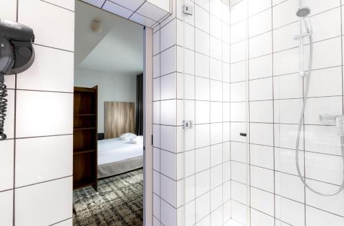 ein Bad mit Dusche und ein Schlafzimmer in der Unterkunft Libertel Austerlitz Jardin des Plantes in Paris