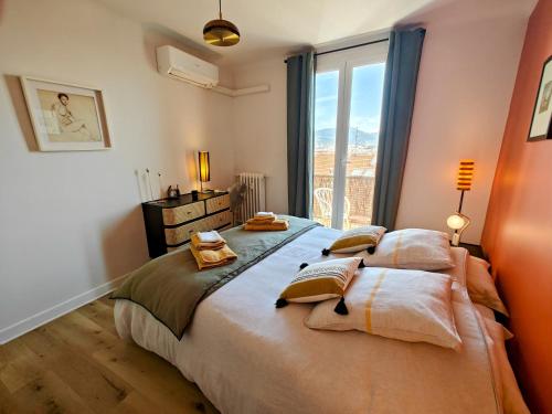 une chambre avec un grand lit avec une grande fenêtre dans l'établissement Cozy roof terrace near Promenade des Anglais - AC, à Nice