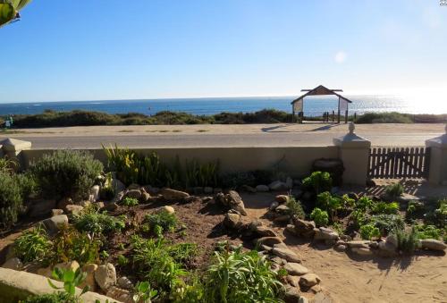 a garden in front of a beach with a gazebo at Polka & Nollies in Port Nolloth