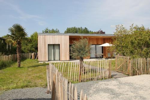 a house with a wooden fence in front of it at Casa Cotentins in Gouville-sur-Mer