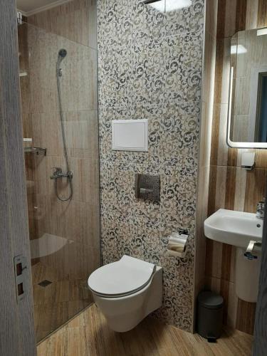 a bathroom with a toilet and a shower and a sink at Апартамент Deluxe 7 in Saints Constantine and Helena