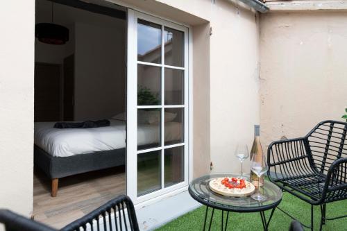 d'une terrasse avec une table, des chaises et un lit. dans l'établissement Villa Sibille - Plein centre de Saint-Tropez, à Saint-Tropez