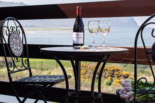 una mesa con dos copas y una botella de vino en 32 Deganwy Beach, en Deganwy