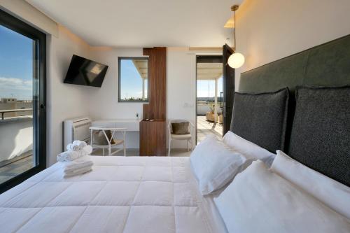 a bedroom with a large white bed with a large window at Bed&Belvedere in Otranto