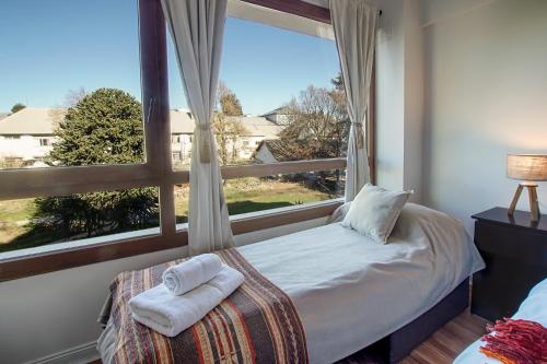 1 dormitorio con cama y ventana grande en Terrazas Bariloche vista en San Carlos de Bariloche