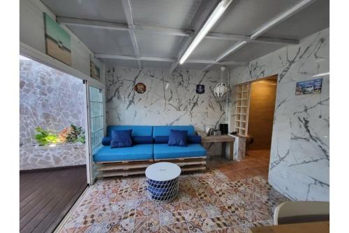 ein blaues Sofa in einem Zimmer mit Marmorwand in der Unterkunft Casa encima del Mar, parquing, 4 patios, idilico in El Escobonal
