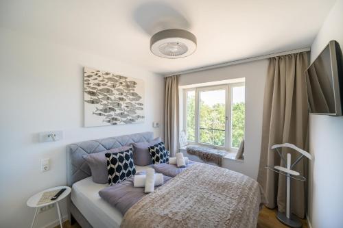 Schlafzimmer mit einem Bett und einem Fenster in der Unterkunft FeWo Prora - Wellenblick inklusive Strandkorb in Binz