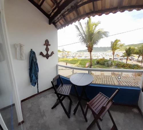 a balcony with a table and chairs and a view of the beach at Pousada Pé Na Areia in Arraial do Cabo