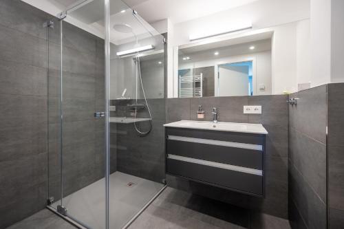 y baño con lavabo y ducha. en FeWo Prora - Wellenblick inklusive Strandkorb, en Binz