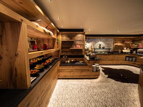 a large kitchen with wooden cabinets and fruits on display at Hotel Franks in Oberstdorf