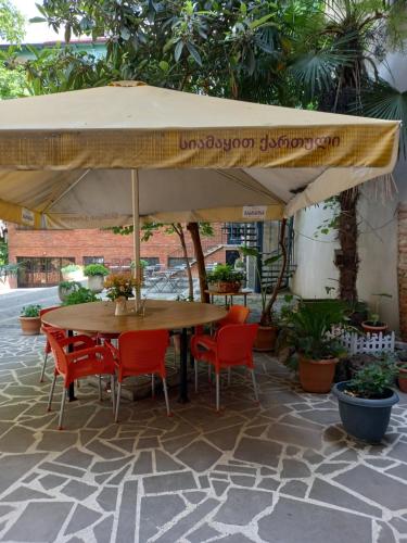 a table and chairs under an umbrella on a patio at Hotel Zaira in Tbilisi City