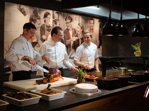 a group of chefs standing in a kitchen preparing food at Hotel Franks in Oberstdorf