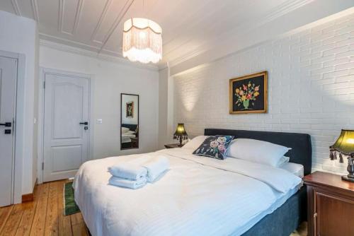 una camera da letto con un grande letto bianco con asciugamani di Historical 4-BR Home Steps from Beşiktaş Stadium & Bosphorus Views - Prime Nişantaşı Location! a Istanbul