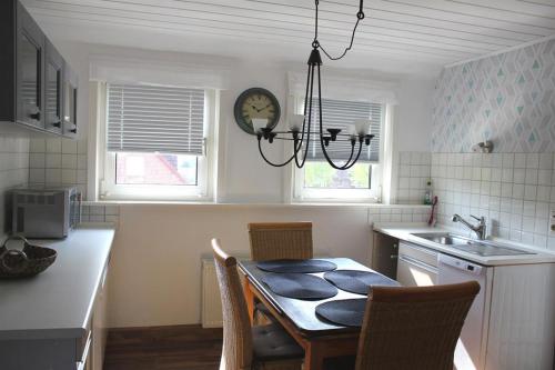 a kitchen with a table and chairs and a clock at Pauls, Ferienwohnung in Celle