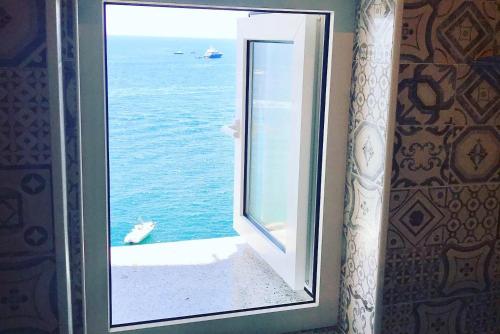 an open window with a view of the ocean at FRENNESIA Amalfi Coast in Atrani