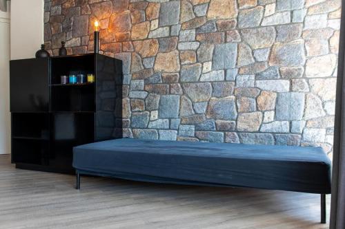 een stenen muur met een blauwe matras voor een muur bij Bed and Breakfast Harvey suite in Delden