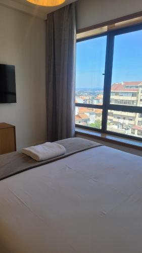sypialnia z dużym łóżkiem i dużym oknem w obiekcie Studio Oporto (Gaia) w mieście Vila Nova de Gaia