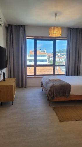 sypialnia z łóżkiem i dużym oknem w obiekcie Studio Oporto (Gaia) w mieście Vila Nova de Gaia