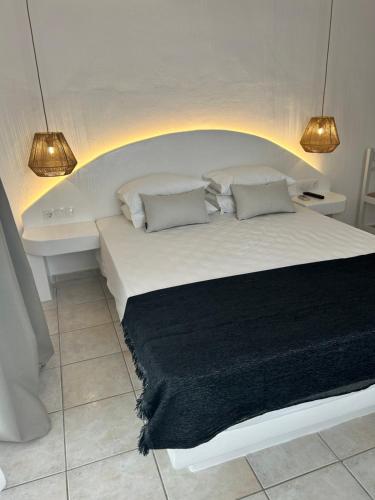 a bedroom with a white bed and a bath tub at Apollonia Studios in Plaka