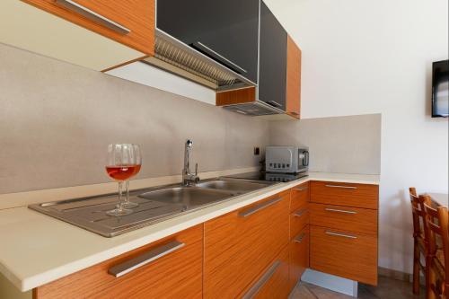 a kitchen with a sink and a glass of wine at Bed&Belvedere in Otranto