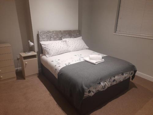a bedroom with a bed in a room with a window at Family-Friendly Chorlton Apartment with Free Street Parking in Sale