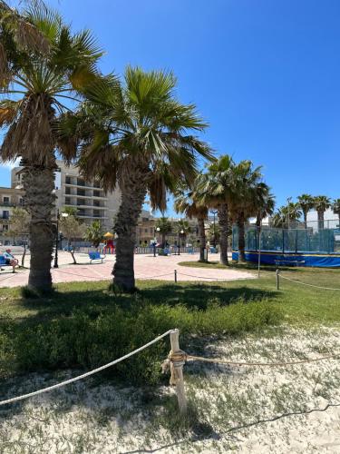 a fire hydrant in a park with palm trees at The Beach House in Birżebbuġa