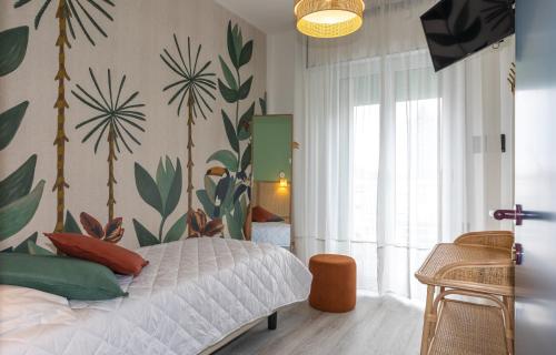 1 dormitorio con 1 cama con plantas en la pared en Hotel Wally, en Lido di Jesolo