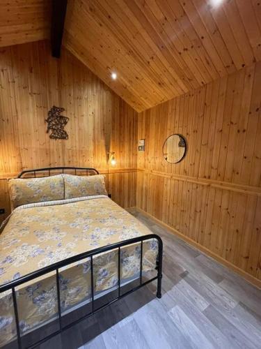 a bedroom with a bed in a wooden room at Taigh Beag in Inverlochy