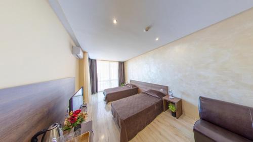 a room with two beds and a couch in it at Aparthotel Paradiso in Nesebar