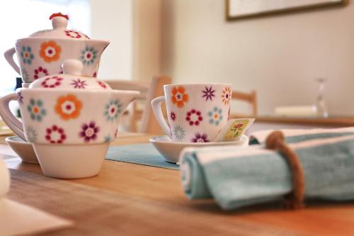 a table with two cups and a teapot at Hotel Santiago in Milano Marittima