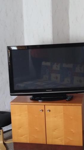 TV de pantalla plana en la parte superior de un armario de madera en Ferienwohnung Hentzschel, en Brand-Erbisdorf